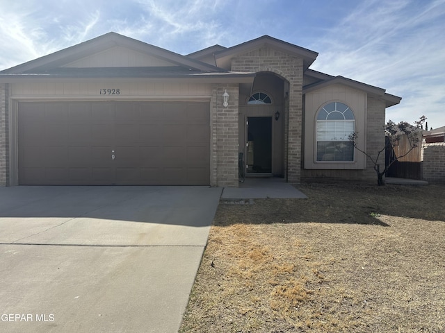 ranch-style home with an attached garage, concrete driveway, and brick siding