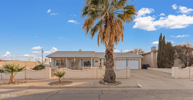 ranch-style home featuring a fenced front yard, driveway, and an attached garage