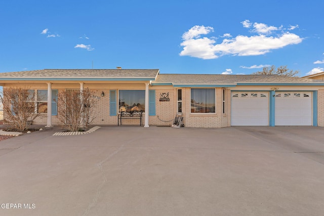 ranch-style home with driveway, an attached garage, and brick siding