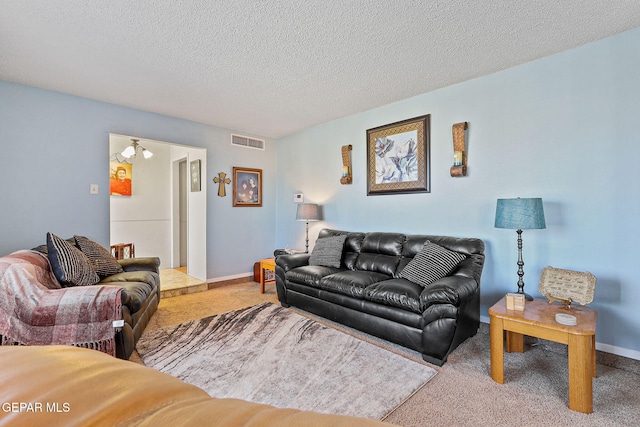 carpeted living area with baseboards, visible vents, and a textured ceiling