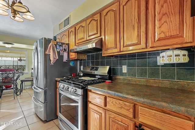 kitchen featuring appliances with stainless steel finishes, brown cabinetry, visible vents, and under cabinet range hood