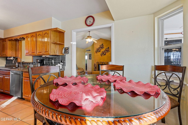 dining space with light tile patterned floors, ceiling fan, and vaulted ceiling