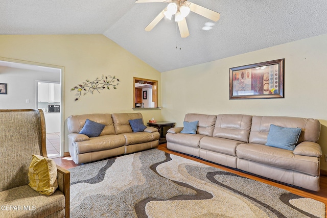 living area featuring lofted ceiling, ceiling fan, and wood finished floors