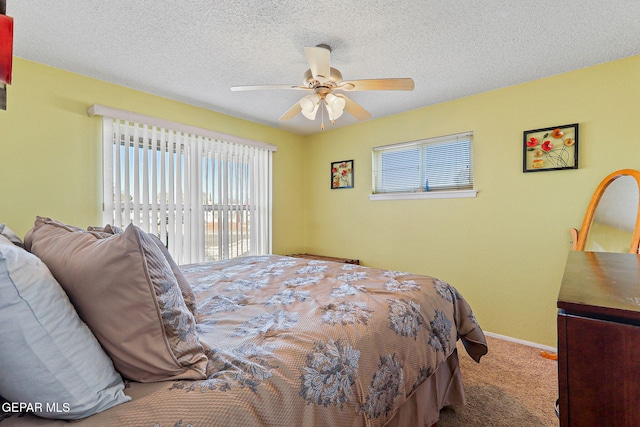 carpeted bedroom featuring a textured ceiling, a ceiling fan, and baseboards