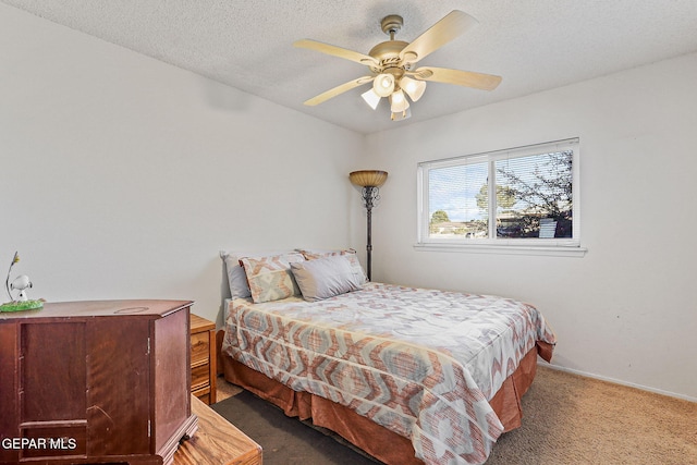 carpeted bedroom featuring ceiling fan and a textured ceiling