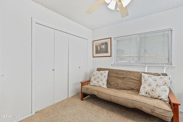 living area with carpet floors, a ceiling fan, and a textured ceiling