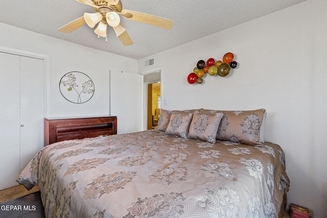 bedroom featuring a ceiling fan, a closet, visible vents, and a textured ceiling