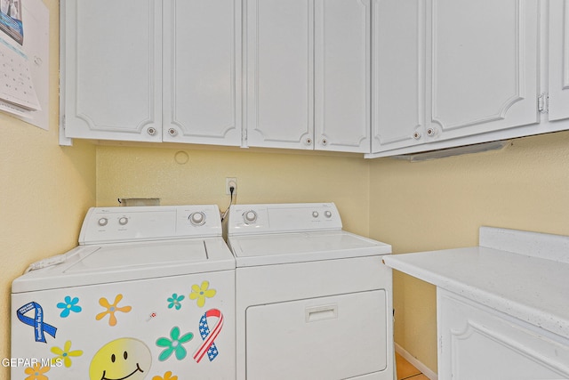 washroom featuring cabinet space and independent washer and dryer