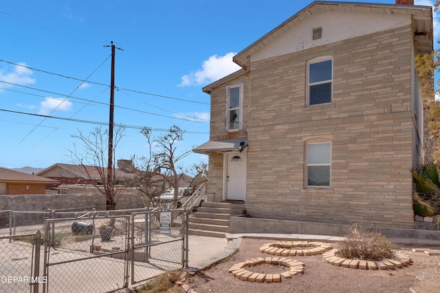 view of front of property with entry steps, a gate, and fence