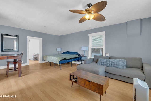 bedroom featuring ceiling fan, light wood-type flooring, and baseboards