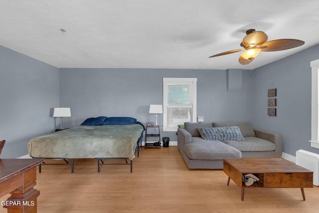 bedroom featuring light wood-style floors, ceiling fan, and baseboards