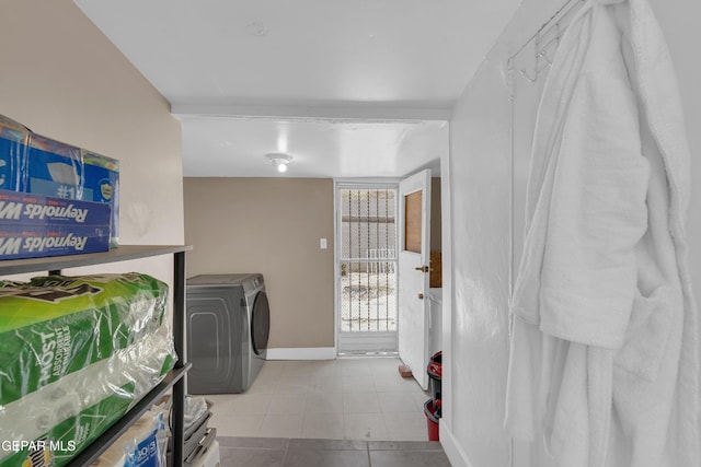 clothes washing area with tile patterned flooring, laundry area, baseboards, and separate washer and dryer