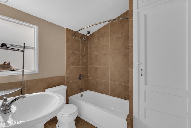 bathroom featuring a sink, bathing tub / shower combination, toilet, and tile patterned floors