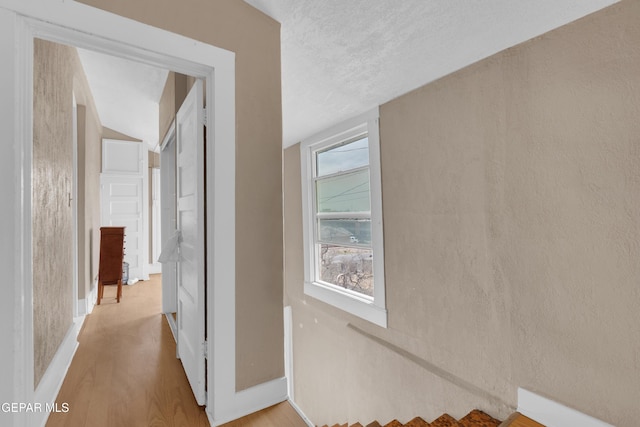 hall with light wood-style floors and baseboards