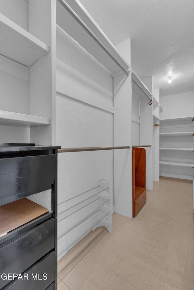 walk in closet with tile patterned floors