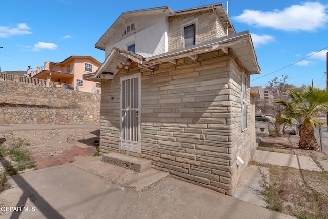 exterior space with stone siding and fence