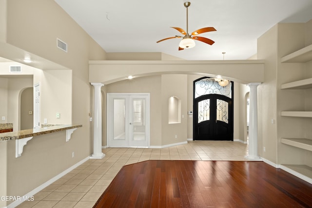 foyer with arched walkways, decorative columns, and visible vents