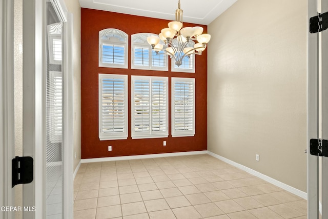 unfurnished room featuring baseboards, a chandelier, and light tile patterned flooring