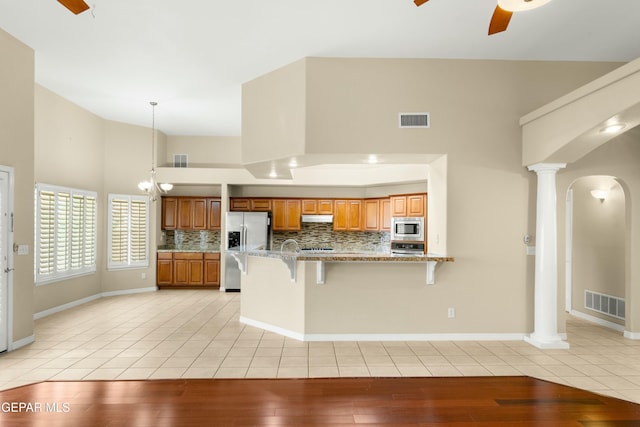 kitchen with stainless steel appliances, brown cabinets, visible vents, and light tile patterned floors