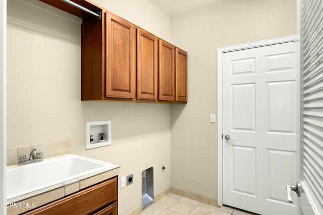 washroom with light tile patterned floors, hookup for a washing machine, hookup for an electric dryer, a sink, and cabinet space