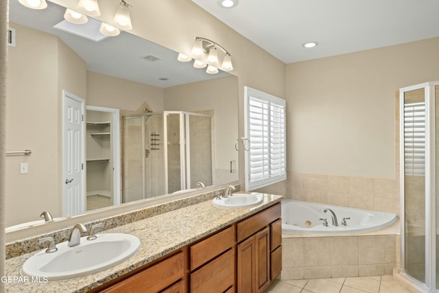 full bath featuring a stall shower, a sink, and tile patterned floors