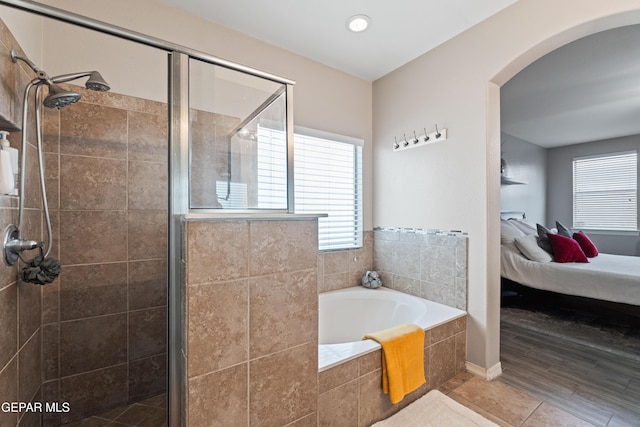 ensuite bathroom with a stall shower, a bath, and ensuite bathroom