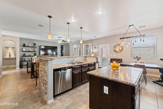 kitchen featuring stainless steel dishwasher, a spacious island, a sink, and visible vents