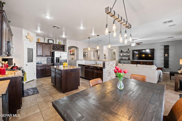 dining space with arched walkways, ceiling fan, light tile patterned flooring, and visible vents