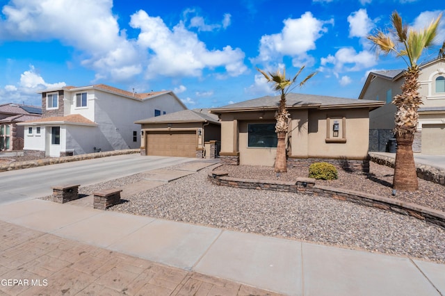 view of front of home featuring a garage, concrete driveway, stone siding, and stucco siding