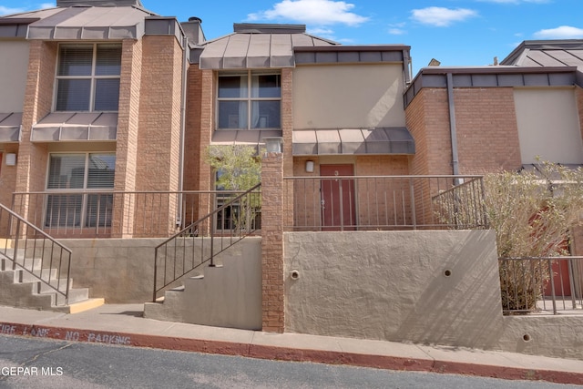 view of front of property featuring brick siding and stairway