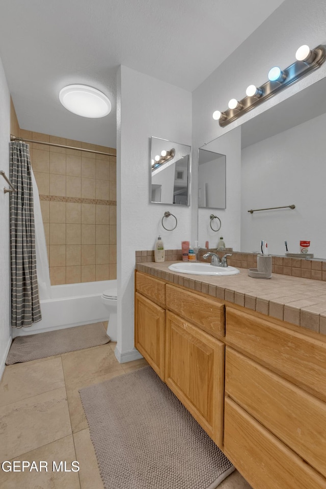 bathroom featuring shower / bath combination with curtain, vanity, toilet, and tile patterned floors