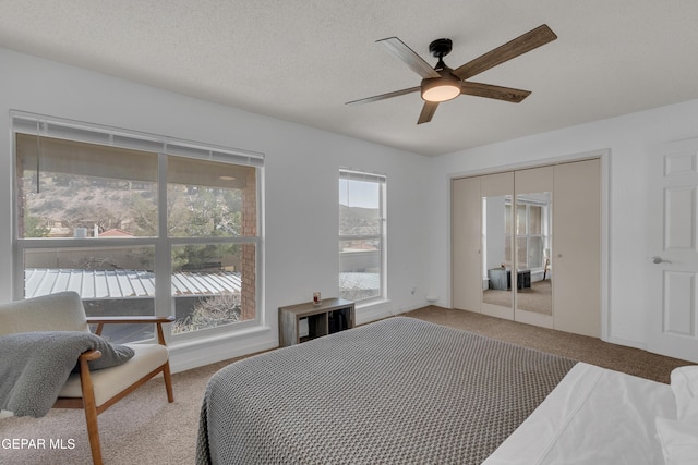 bedroom featuring a textured ceiling, a ceiling fan, and carpet flooring