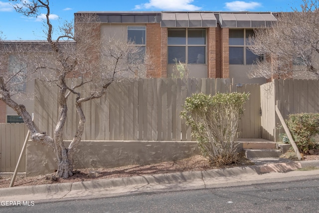 view of home's exterior with brick siding and fence