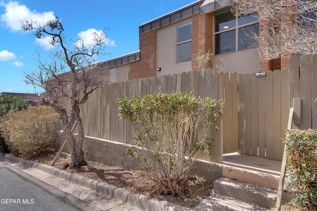 view of home's exterior featuring fence and brick siding