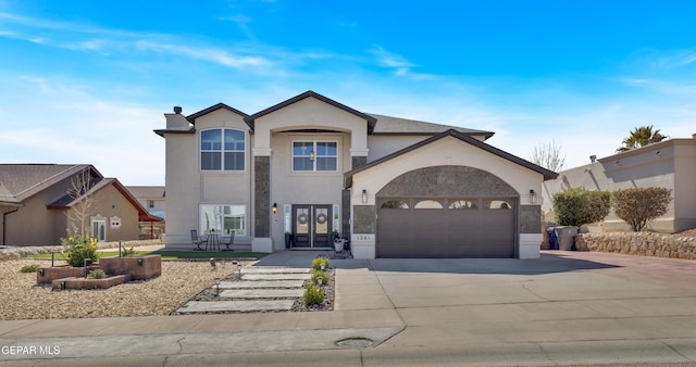 view of front of property featuring concrete driveway, an attached garage, and stucco siding