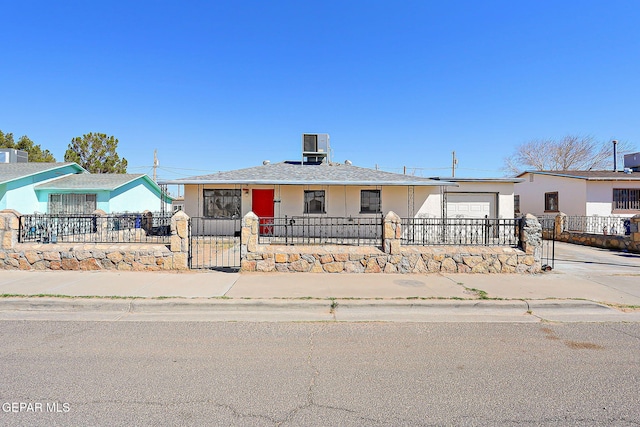 view of front of property with a garage, driveway, and a fenced front yard