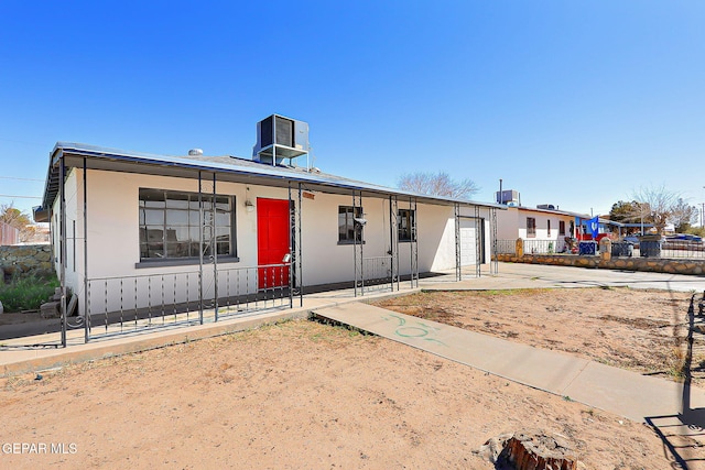 view of front of house featuring a garage, central AC, a porch, and fence