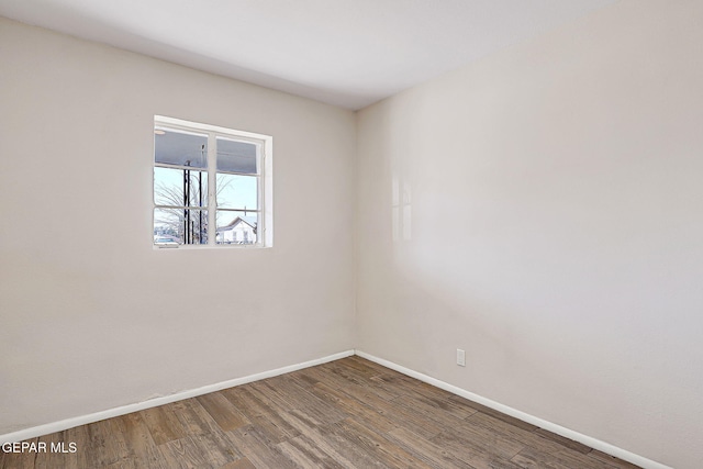 spare room with wood finished floors and baseboards