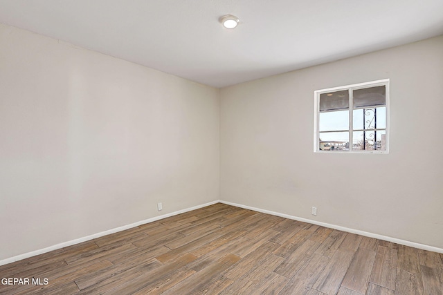 unfurnished room featuring wood finished floors and baseboards