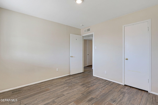 unfurnished bedroom featuring wood finished floors, visible vents, and baseboards