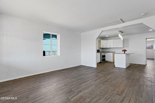 unfurnished living room featuring baseboards, visible vents, dark wood finished floors, and recessed lighting