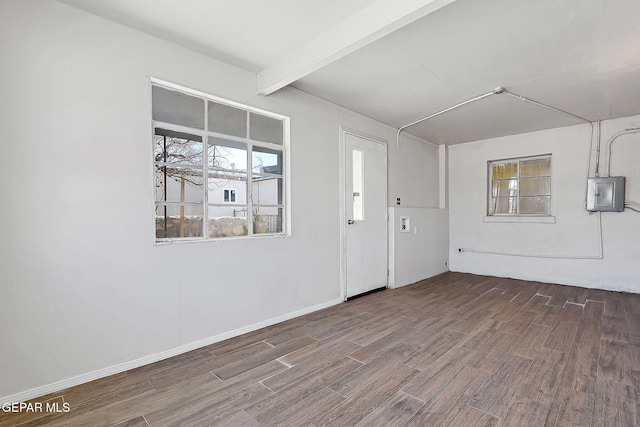 interior space featuring electric panel, beamed ceiling, baseboards, and wood finished floors