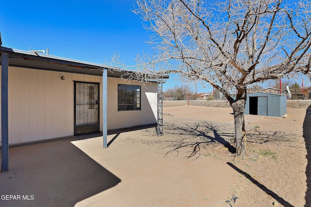 view of patio featuring a storage unit and an outdoor structure