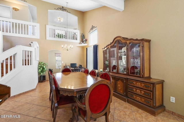 dining area featuring a chandelier, arched walkways, a healthy amount of sunlight, and tile patterned floors