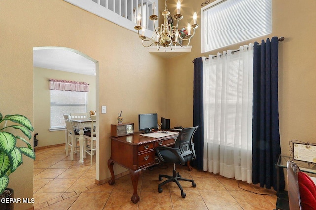 tiled office featuring arched walkways, an inviting chandelier, and baseboards