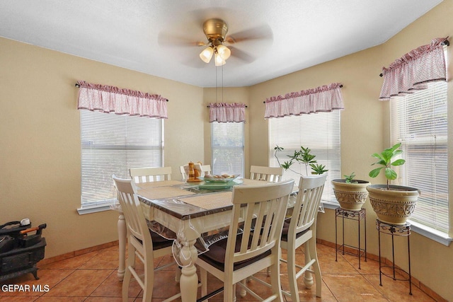 dining room with ceiling fan, light tile patterned flooring, and baseboards