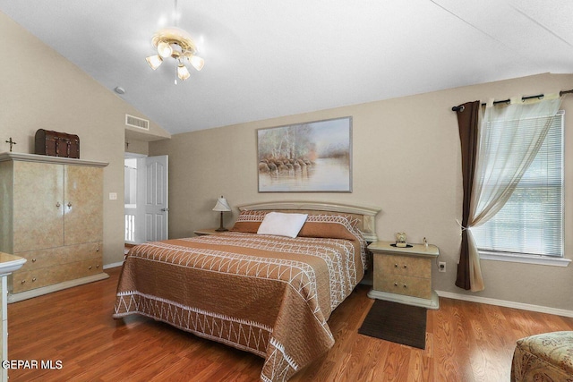 bedroom featuring visible vents, vaulted ceiling, baseboards, and wood finished floors