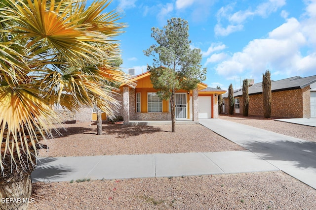 ranch-style home featuring a garage, concrete driveway, and brick siding