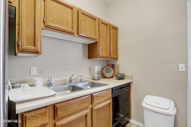 kitchen featuring light countertops, dishwasher, and a sink