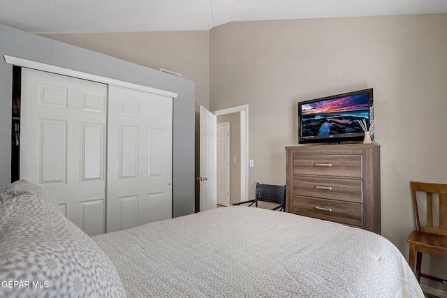 bedroom with lofted ceiling and a closet